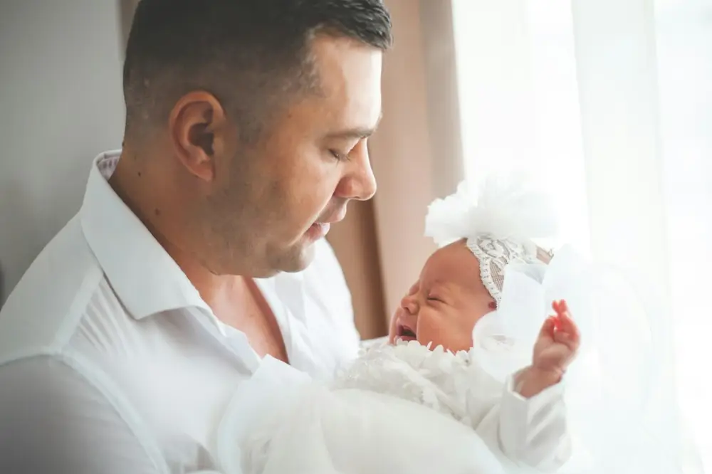 Father holding his crying newborn baby girl, illustrating becoming a father